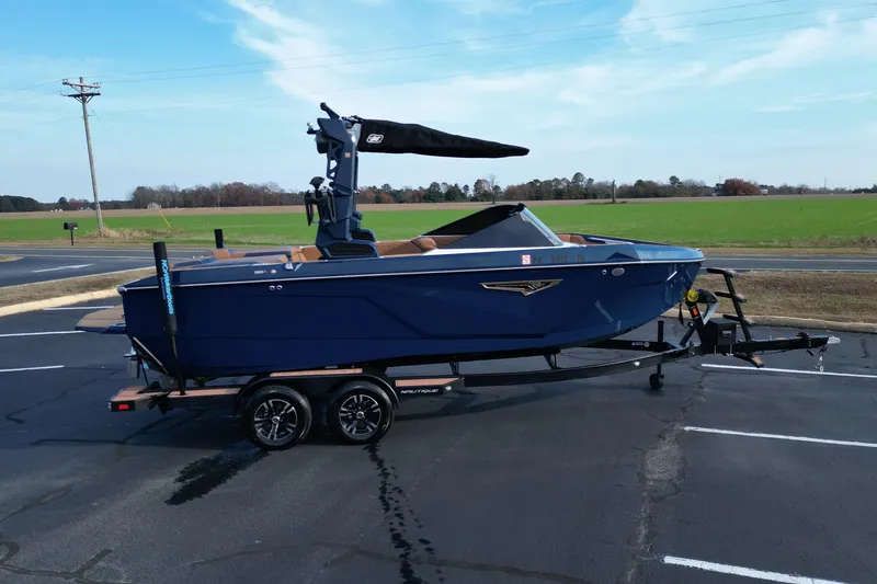 Slide: The Image of 2024 Nautique Super Air Nautique S21 boat on trailer, parked in a lot. - 3