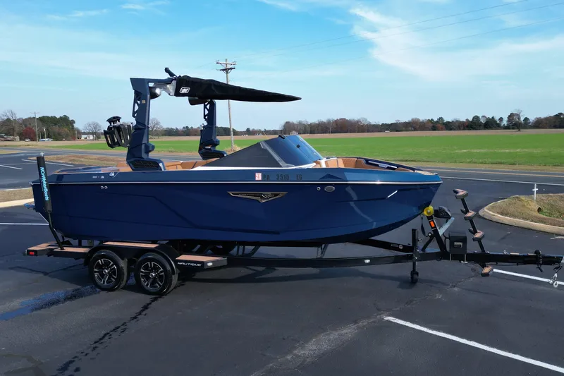 Slide: The Image of 2024 Nautique Super Air Nautique S21 boat on trailer, parked in a lot. - 6