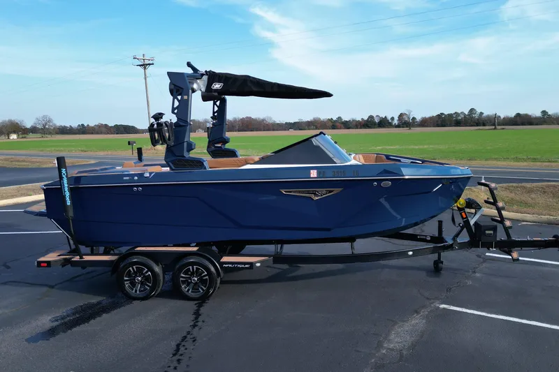 Slide: The Image of 2024 Nautique Super Air Nautique S21 boat on trailer, parked in a lot. - 7