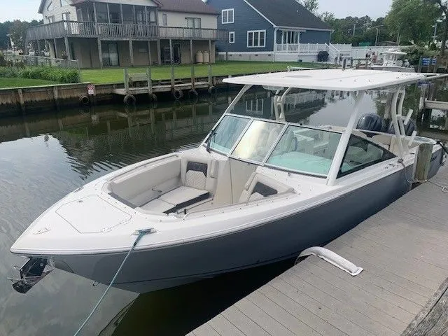 The Image of 2023 Sailfish 276DC boat docked by waterfront homes. - 0