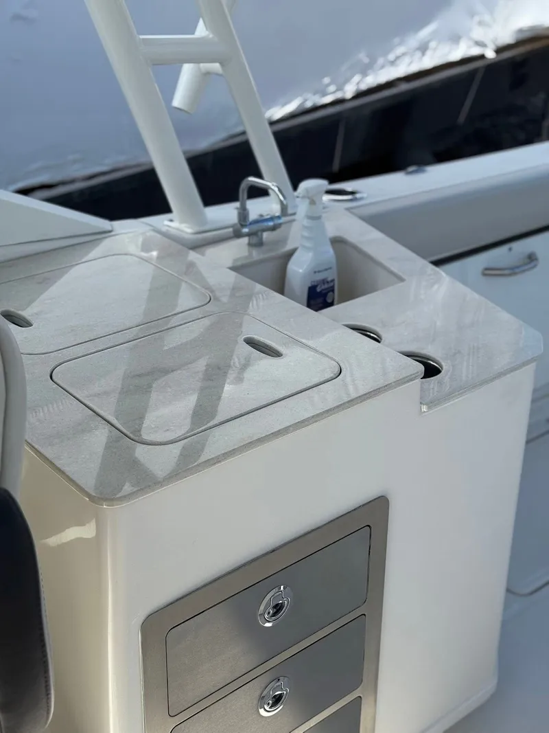 Slide: The Image of 2023 Sailfish 276DC boat interior with sink, storage drawers, and countertop. - 10