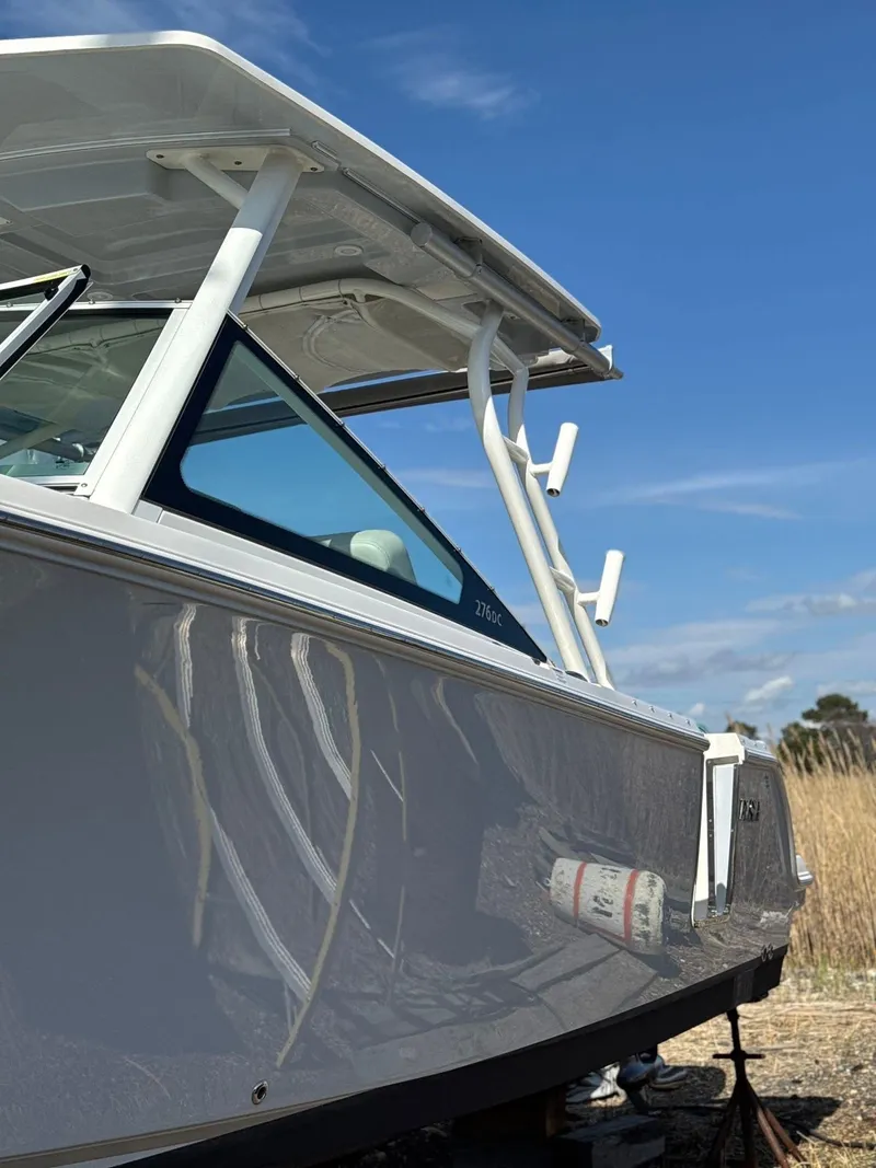 Slide: The Image of 2023 Sailfish 276DC boat with sleek design under a clear blue sky. - 8
