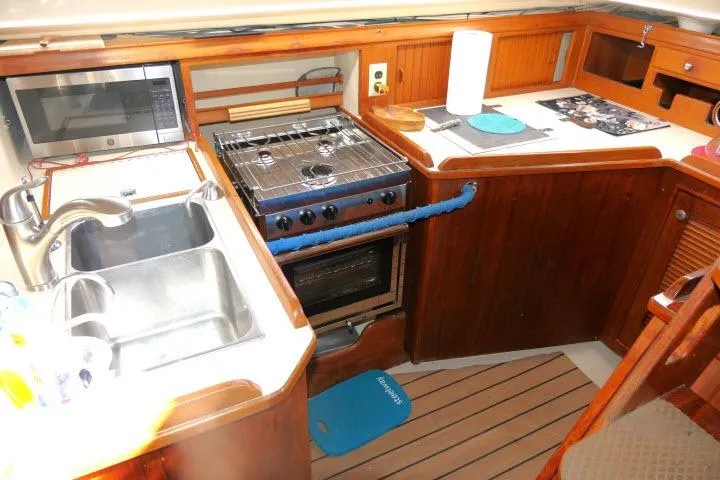 Slide: The Image of Galley kitchen in 1999 Island Packet 45 sailboat with stove, sink, and microwave. - 12