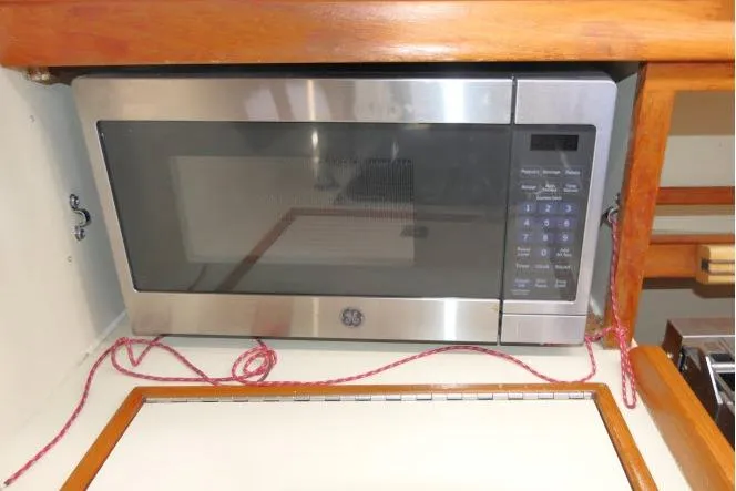 Slide: The Image of Microwave in 1999 Island Packet 45 yacht kitchen with wooden cabinetry. - 14