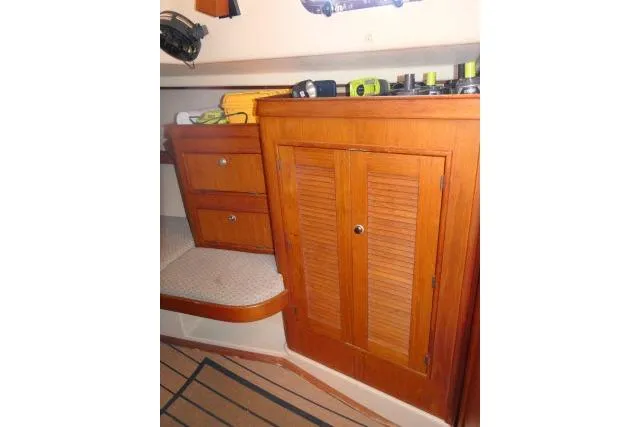 Slide: The Image of Interior of 1999 Island Packet 45 sailboat with wooden cabinetry and storage. - 21