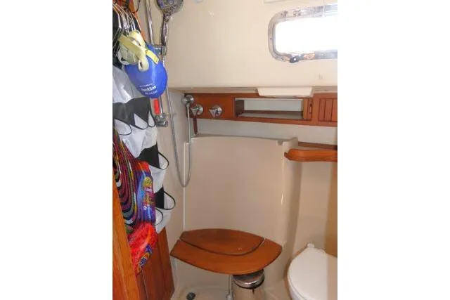 Slide: The Image of 1999 Island Packet 45 yacht bathroom with shower, wooden accents, and storage. - 22