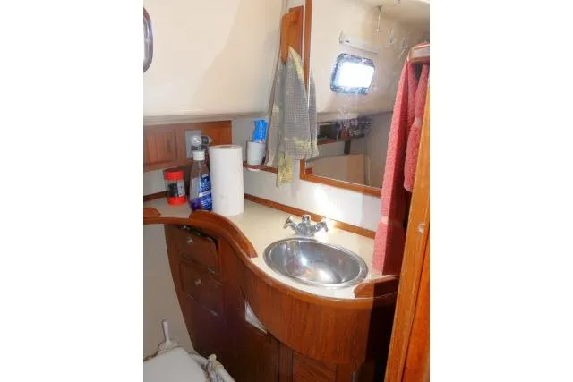 Slide: The Image of 1999 Island Packet 45 yacht bathroom with wooden cabinetry and stainless steel sink. - 23