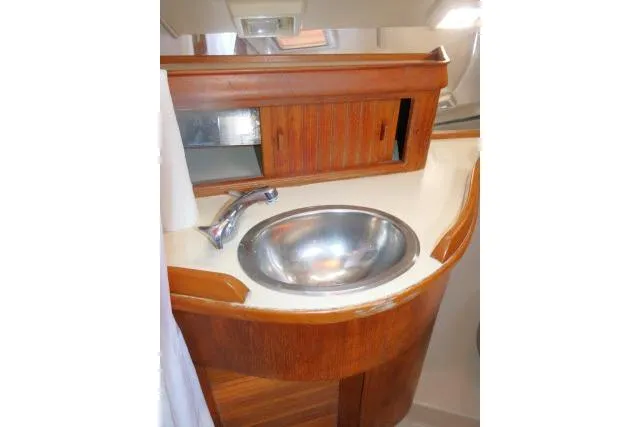 Slide: The Image of 1999 Island Packet 45 yacht bathroom with wooden cabinetry and stainless steel sink. - 24