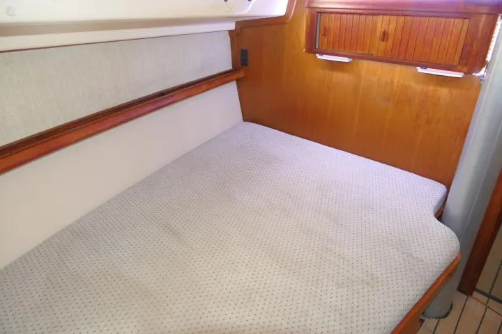 Slide: The Image of 1999 Island Packet 45 yacht interior cabin with wooden accents and comfortable bedding. - 25