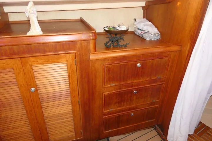 Slide: The Image of Wooden cabinetry inside a 1999 Island Packet 45 yacht, featuring drawers and a louvered door. - 27