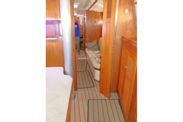 Slide: The Image of Interior of 1999 Island Packet 45 sailboat with wooden finishes and cozy seating area. - 28