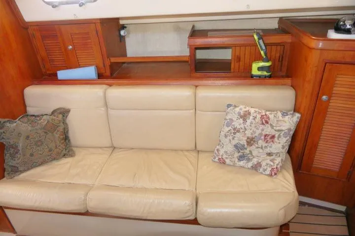 Slide: The Image of Interior of 1999 Island Packet 45 yacht with beige leather sofa and floral cushions. - 4