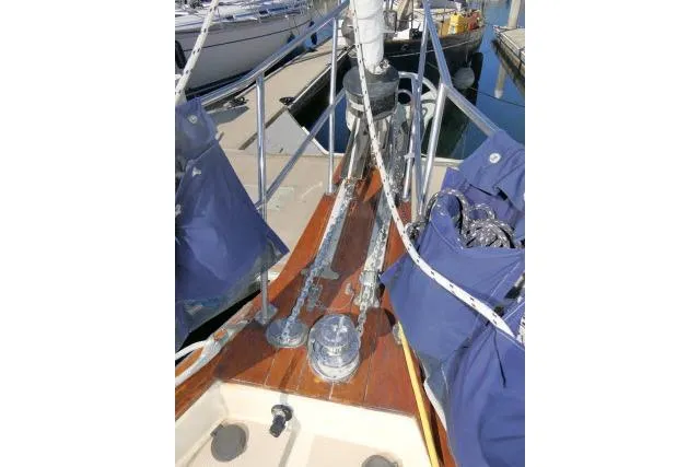 Slide: The Image of 1999 Island Packet 45 sailboat deck with blue covers and rigging at a marina. - 43