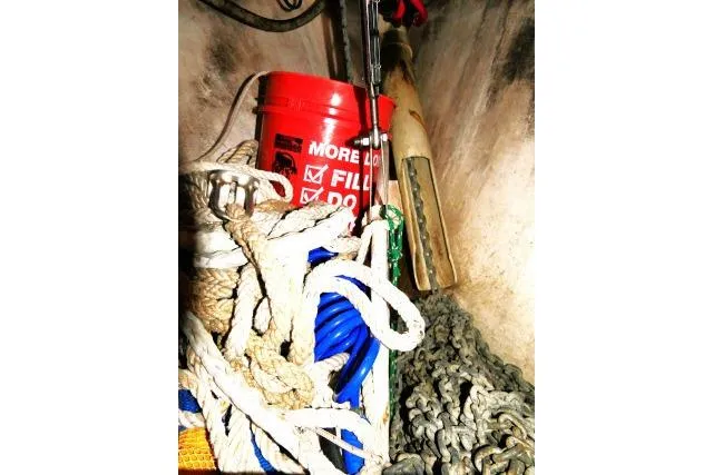 Slide: The Image of Storage compartment on a 1999 Island Packet 45 with ropes, chains, and a red bucket. - 44
