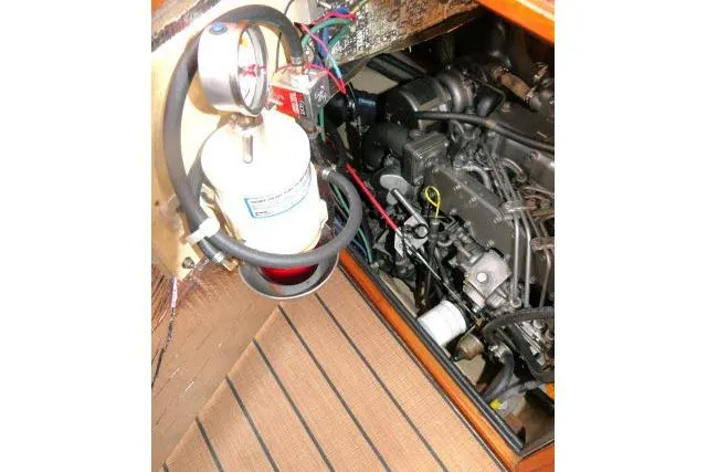 Slide: The Image of Engine compartment of 1999 Island Packet 45 sailboat, featuring mechanical components and fire extinguisher. - 53