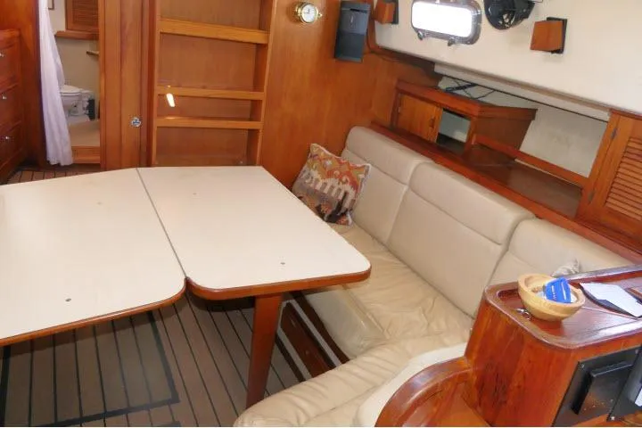 Slide: The Image of Interior of 1999 Island Packet 45 sailboat with dining area and wooden furnishings. - 6