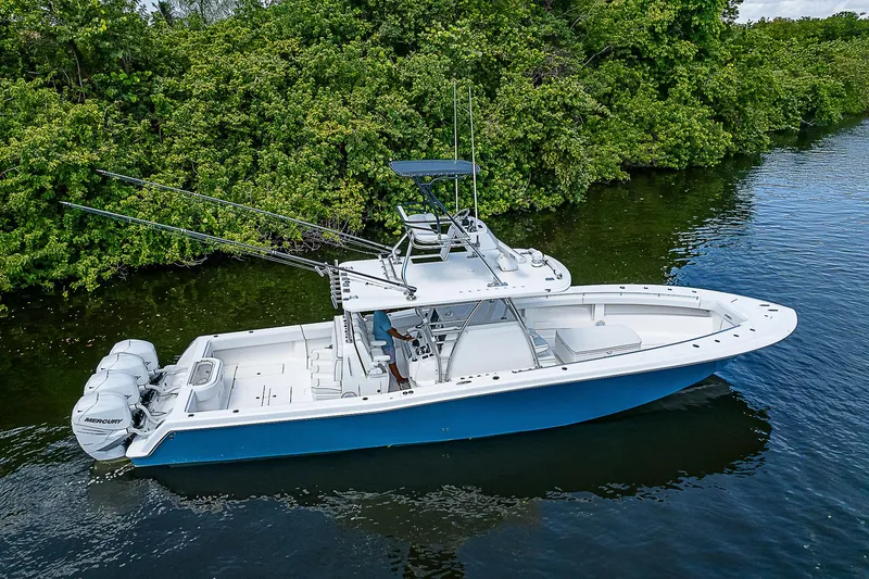 Slide: The Image of 2018 Invincible 42 boat with triple Mercury engines on a calm waterway. - 2