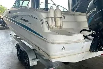 Slide: The Image of 2000 Hurricane SunDeck 237 OB boat on trailer, featuring Mercury outboard motor. - 10