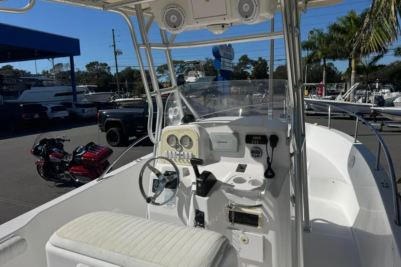 Slide: The Image of 2006 PROLINE 23 boat interior with steering wheel, gauges, and seating in a sunny marina. - 17