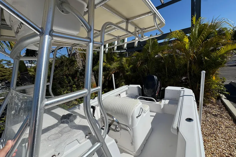 Slide: The Image of 2006 PROLINE 23 boat with seating and canopy, surrounded by lush greenery. - 31