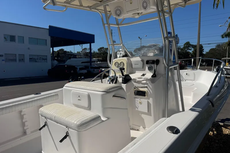Slide: The Image of 2006 PROLINE 23 boat interior with steering console and seating, parked outdoors. - 7