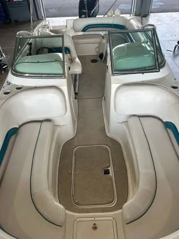 Slide: The Image of 2000 Hurricane SunDeck SD 237 OB boat interior with white seating and teal accents. - 5