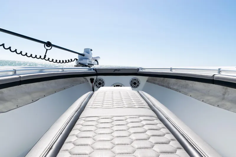 Slide: The Image of 2019 Yellowfin 36 Offshore boat interior with cushioned seating and ocean view. - 13