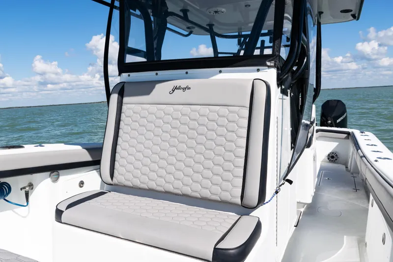 Slide: The Image of 2019 Yellowfin 36 Offshore boat interior with cushioned seating, on a sunny day at sea. - 18