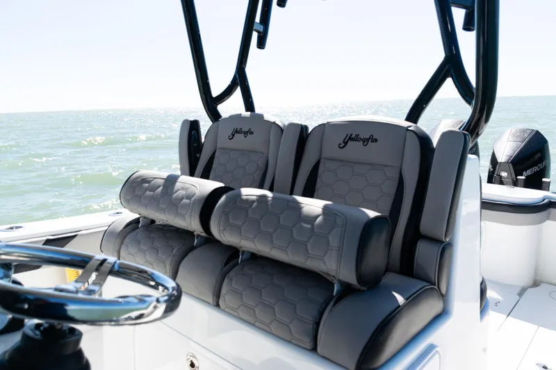 Slide: The Image of 2019 Yellowfin 36 Offshore boat interior with cushioned seating and ocean view. - 23