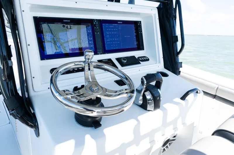 Slide: The Image of 2019 Yellowfin 36 Offshore boat dashboard with dual Simrad displays and chrome steering wheel. - 28