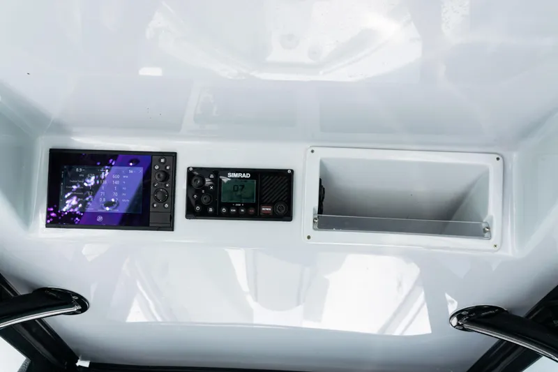 Slide: The Image of 2019 Yellowfin 36 Offshore dashboard with Simrad electronics and storage compartment. - 30