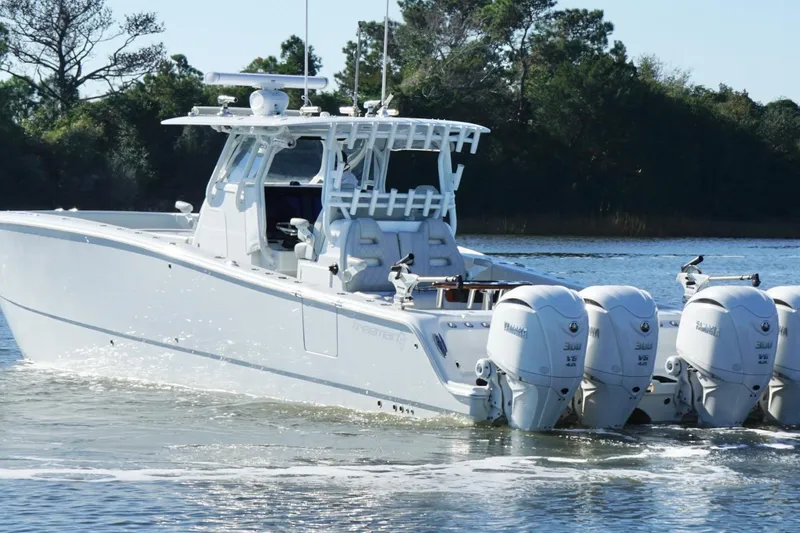 Slide: The Image of 2024 Freeman 38 boat with four Yamaha engines cruising on a calm lake. - 11