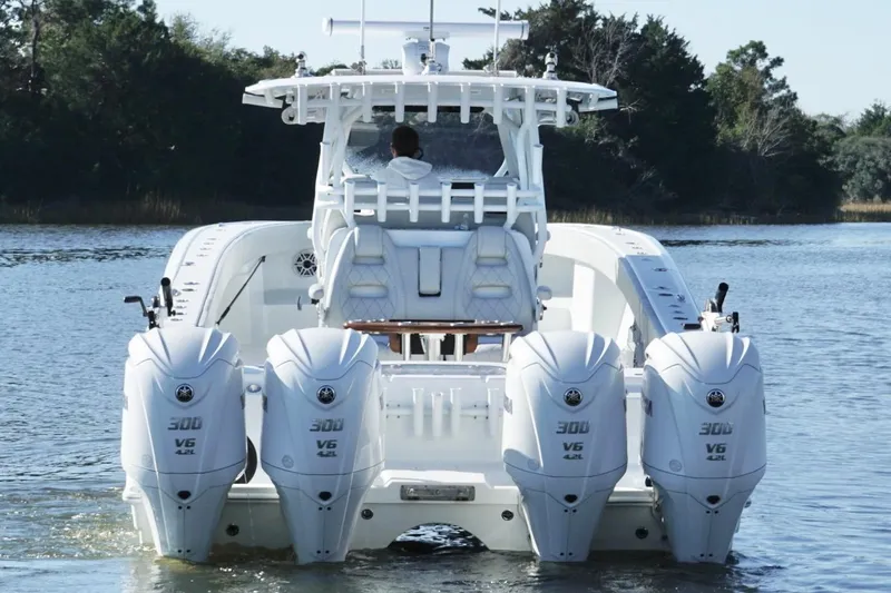 Slide: The Image of 2024 Freeman 38 boat with four powerful outboard engines on a calm waterway. - 12