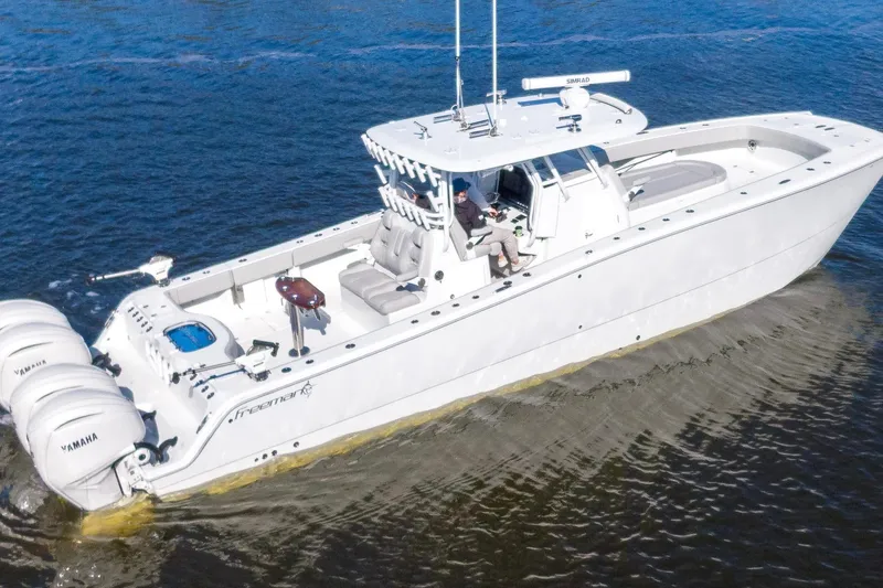 Slide: The Image of 2024 Freeman 38 boat cruising on water with multiple Yamaha engines. - 14