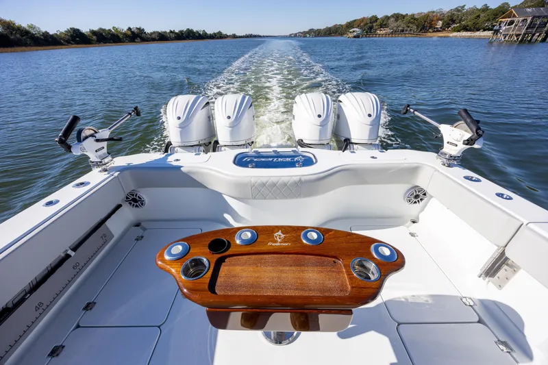 Slide: The Image of 2024 Freeman 38 boat with four engines, cruising on a scenic waterway. - 15