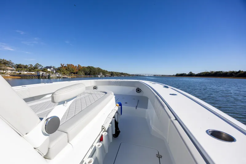 Slide: The Image of 2024 Freeman 38 boat cruising on a serene river under a clear blue sky. - 18