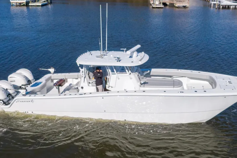 Slide: The Image of 2024 Freeman 38 boat cruising on calm waters with dual Yamaha engines. - 3