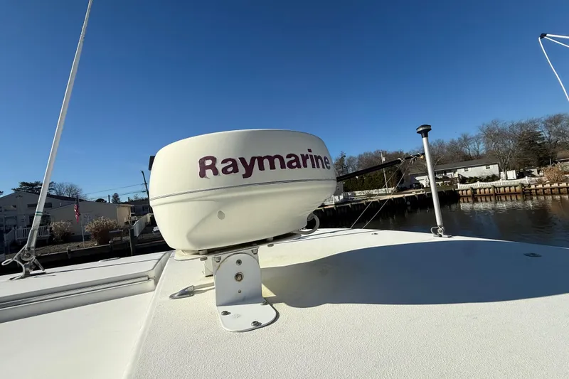 Slide: The Image of 2002 Wellcraft 290 Coastal boat with Raymarine radar, docked by a serene waterfront. - 19