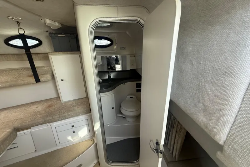 Slide: The Image of Interior of 2002 Wellcraft 290 Coastal boat showing compact bathroom and storage area. - 24
