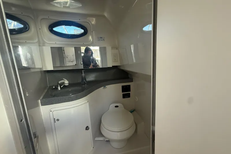 Slide: The Image of 2002 Wellcraft 290 Coastal boat bathroom with sink, toilet, and mirror. - 25