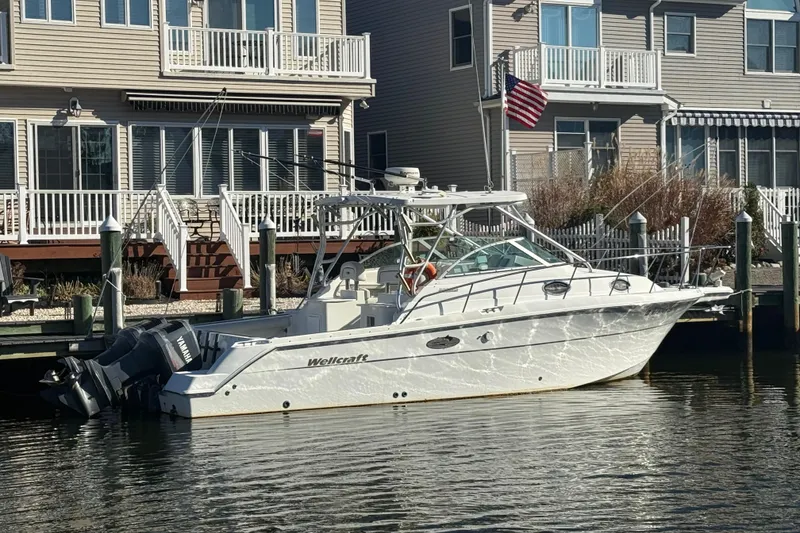 The Image of 2002 Wellcraft 290 Coastal boat docked near waterfront homes. - 3