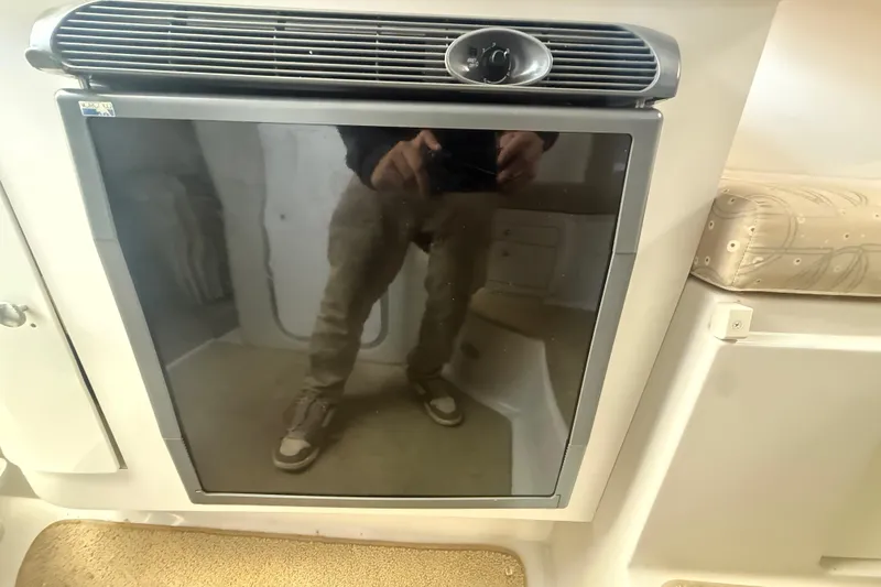 Slide: The Image of 2002 Wellcraft 290 Coastal interior with a reflective refrigerator door. - 30
