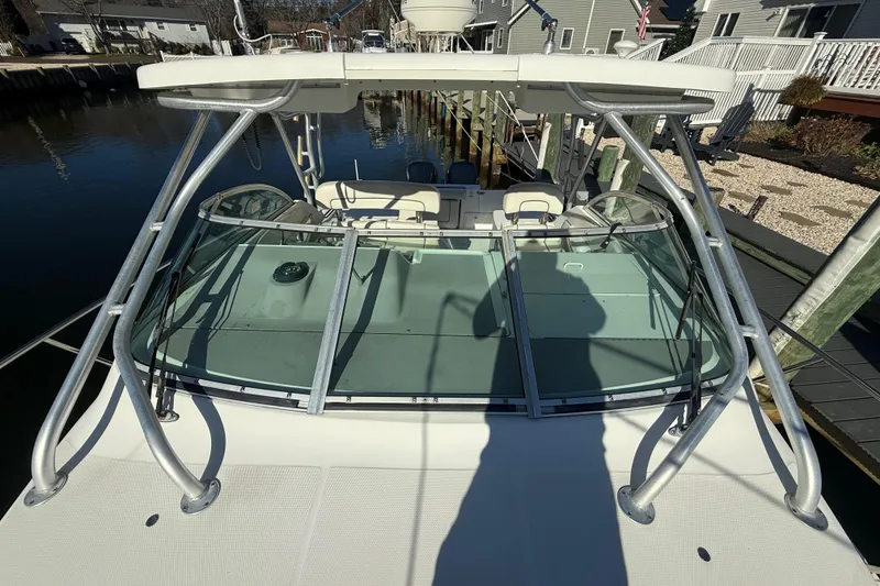 Slide: The Image of 2002 Wellcraft 290 Coastal boat docked, featuring a sturdy frame and spacious deck. - 5