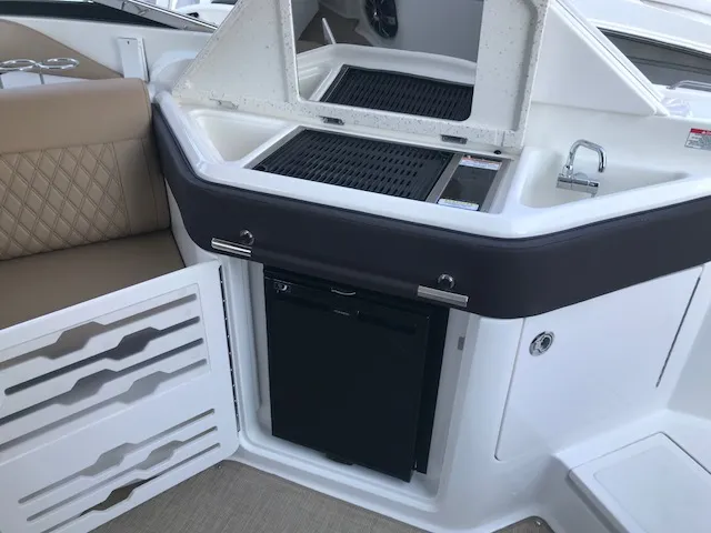 Slide: The Image of 2019 Sea Ray 310 SLX boat interior with kitchenette and seating area. - 12