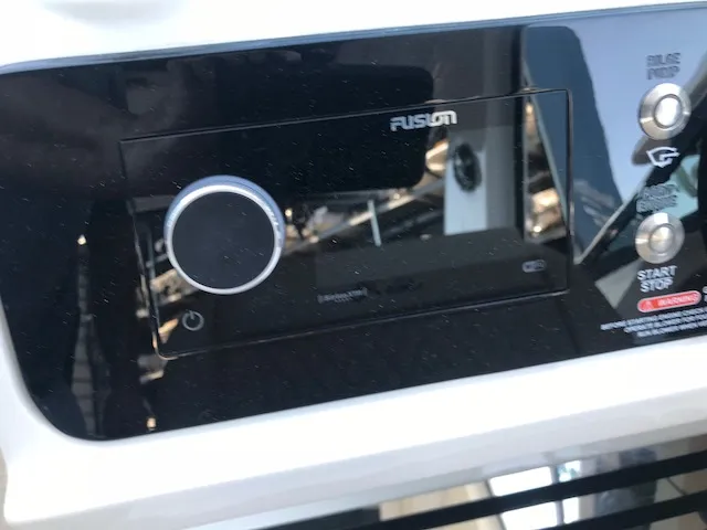 Slide: The Image of Control panel of a 2019 Sea Ray 310 SLX boat featuring a Fusion audio system. - 19