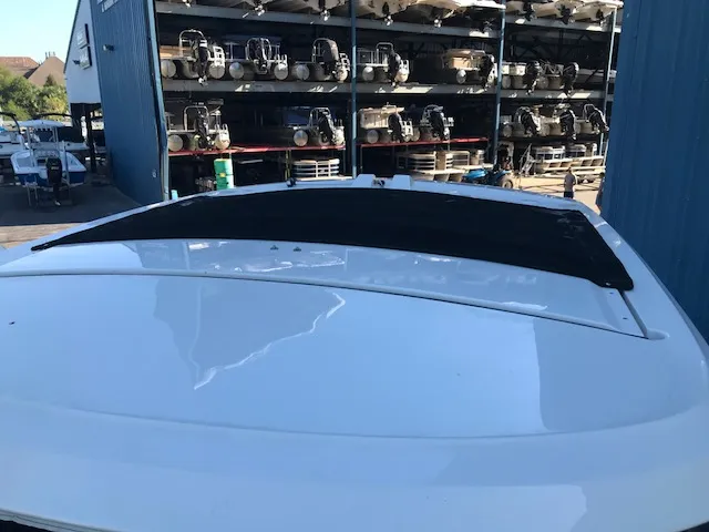 Slide: The Image of 2019 Sea Ray 310 SLX boat in storage facility, surrounded by other boats. - 24