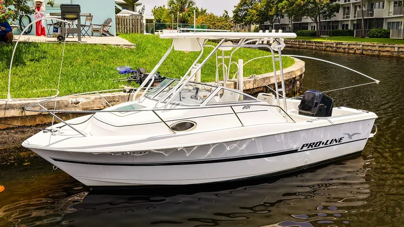 The Image of 1999 Pro-Line 201 Walkaround boat docked on a calm canal. - 1