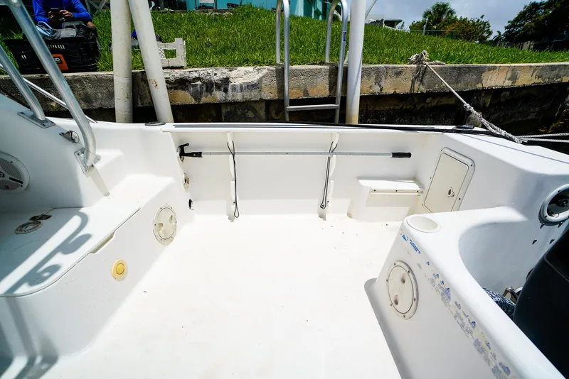 Slide: The Image of 1999 Pro-Line 201 Walkaround boat interior with clean white deck and storage compartments. - 10