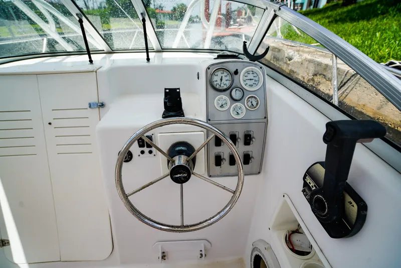 Slide: The Image of 1999 Pro-Line 201 Walkaround boat dashboard with steering wheel and gauges. - 11