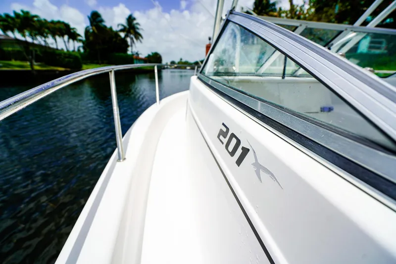 Slide: The Image of 1999 Pro-Line 201 Walkaround boat cruising on a scenic waterway. - 14